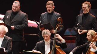 Zingende mannen met orkest tijdens een uitvoering van The Bach Orchestra of the Netherlands