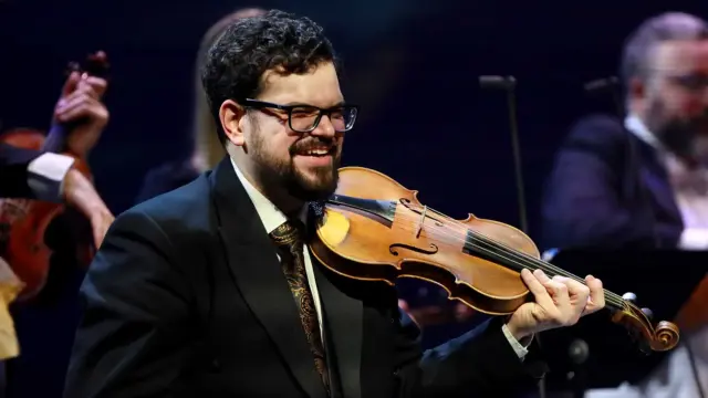 Lachende violist van The Bach Orchestra of the Netherlands tijdens een uitvoering