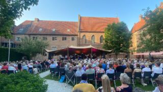 Openluchtconcert met publiek in Kloostertuin in Elburg
