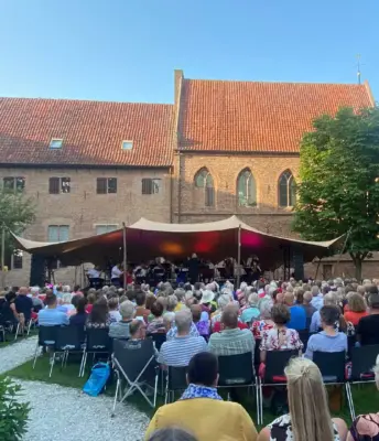 Klassiek openluchtconcert met orkest en publiek in historische Kloostertuin in Elburg